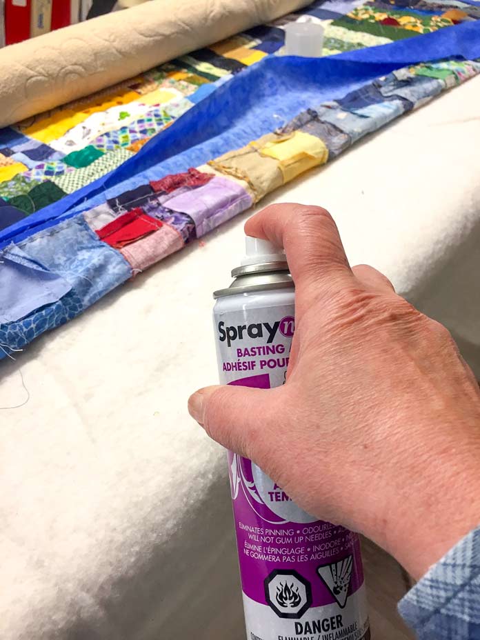 SpraynBond Basting Adhesive, spraying the layers of quilt on a long arm machine so that they do not move while the machine is in operation. Great for domestic and long arm quilters alike!