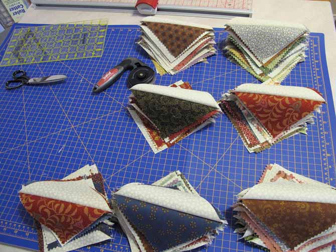 Half Square Triangles on a Unique cutting mat to make a quilt