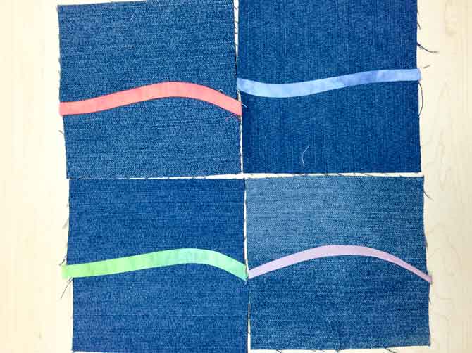 4 denim quilt blocks made with cotton wave strip in middle.