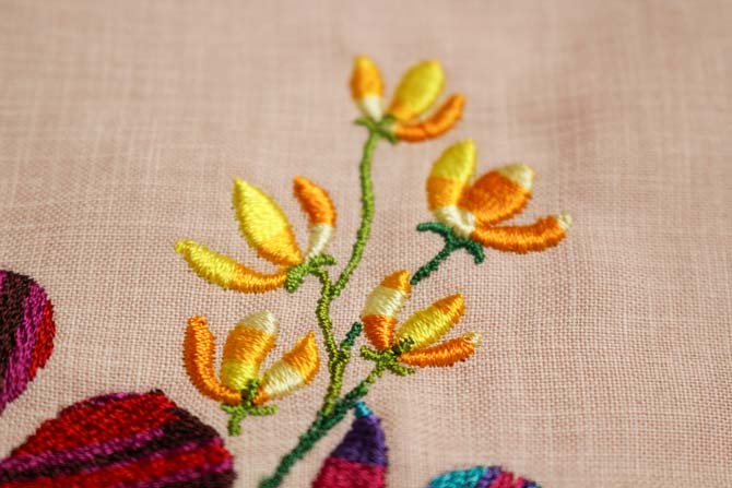Variegated yellow flowers which have been machine embroidered with WonderFil's Mirage rayon thread.