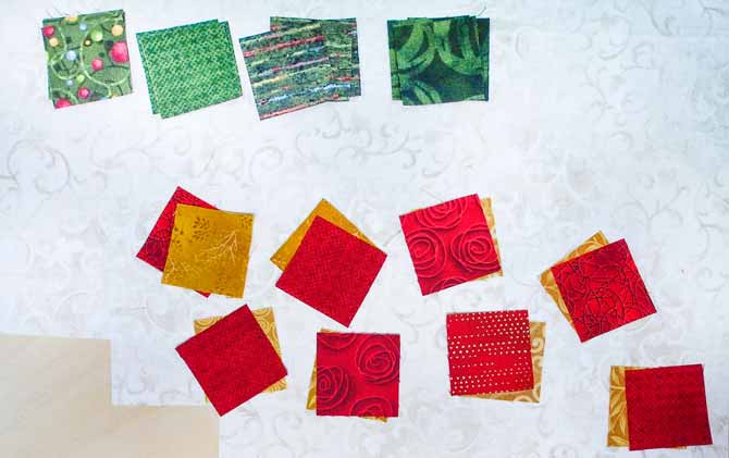 red, gold and green squares on cream fabric with the red and gold squares paired up together