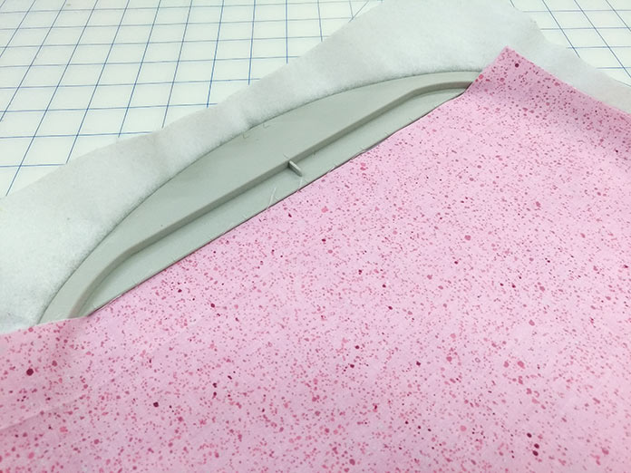 Line the top edge of the fabric to the inside of the hoop on the Brother Luminaire XP