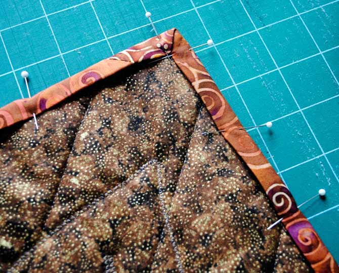 Pinning the binding to the back of the quilt