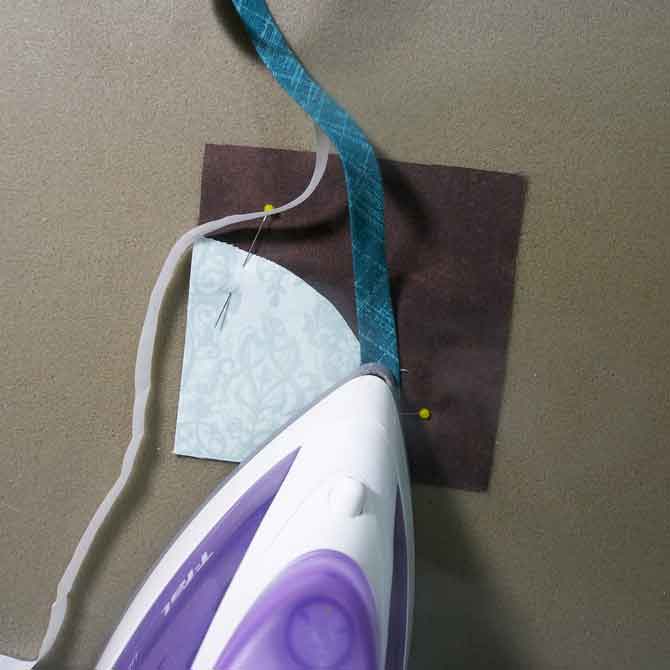 Use a hot iron to secure tape to curve