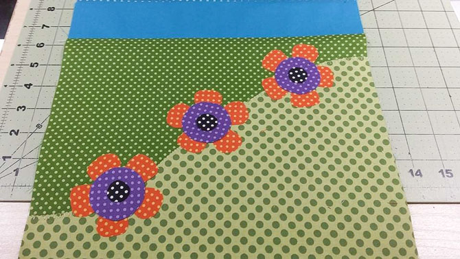 The wonderful flower appliques made with Northcott's Urban Elementz Basix fabrics are positioned on the ends of the spring table runner.