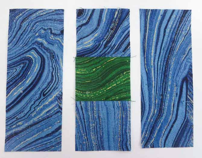 Sew a 2½" green square to 2 – 2½" blue squares. Press seams toward blue.