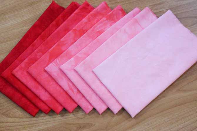 Eight gradations of Dylon Permanent Fabric Dye in Tulip Red from light to dark