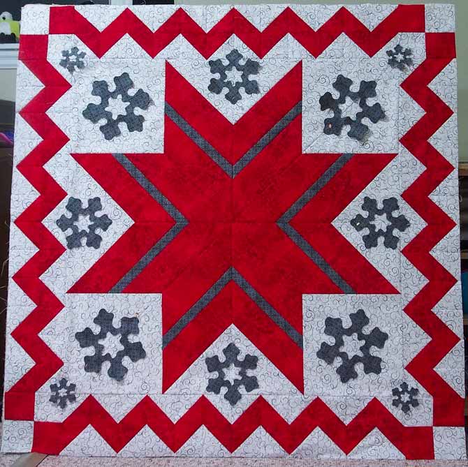 Snowflakes pinned in position on the quilt top