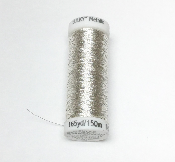 A spool of silver Sulky metallic thread  Sulky