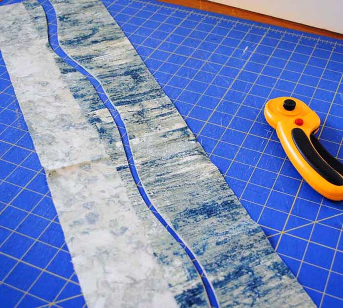 The first wavy cut through the two overlapping fabric strips