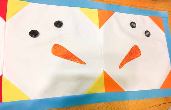 Two snowman faces of quilt top table runner.