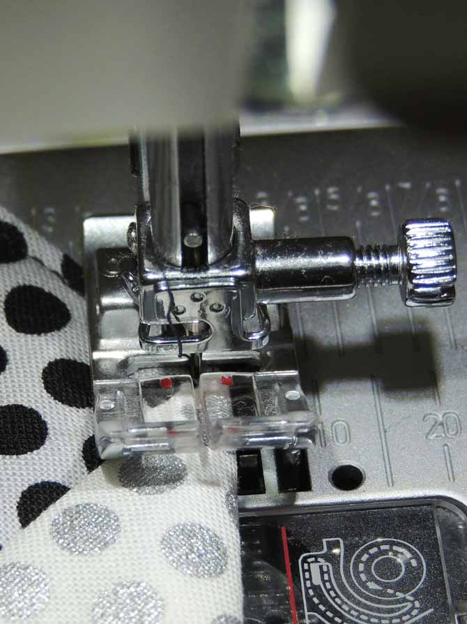 The passport 3.0 presser foot has red marks on each side of the needle to follow in order to make topstitching consistent.